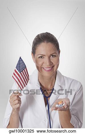 Stock Photography - Female doctor holding an American flag. Fotosearch