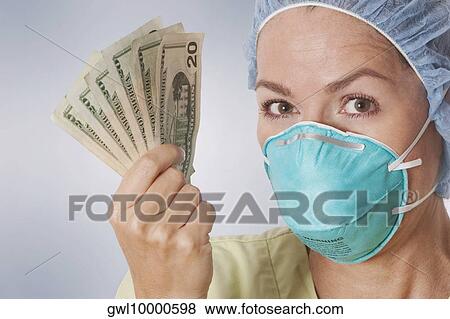 Female doctor holding currency notes View Large Photo Image Stock Photo - Female doctor holding currency notes. Fotosearch