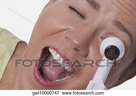 Female doctor looking through an otoscope View Large Photo Image Stock Photo - Female doctor looking through an otoscope. Fotosearch