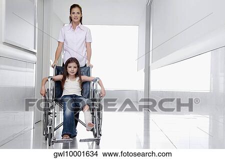 Female doctor pushing a patient in a wheelchair View Large Photo Image Picture - Female doctor pushing a patient in a wheelchair. Fotosearch