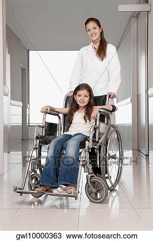 Female doctor pushing a patient in a wheelchair View Large Photo Image Stock Image - Female doctor pushing a patient in a wheelchair. Fotosearch