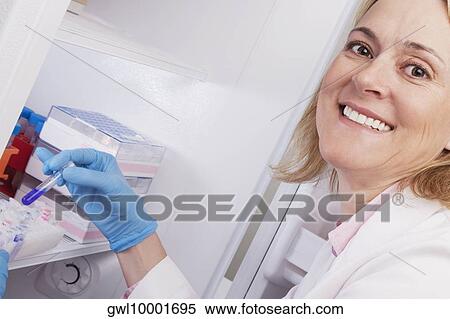 Stock Photography - Female doctor smiling and researching in a laboratory. Fotosearch