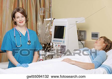Stock Image - Female doctor standing near a patient. Fotosearch