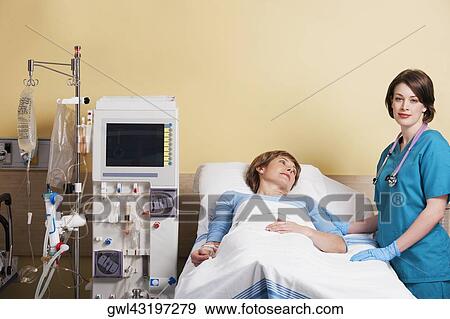 Female doctor standing near a patient View Large Photo Image Stock Photo - Female doctor standing near a patient. Fotosearch