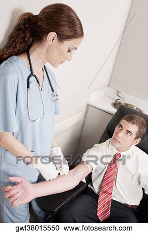 Female doctor taking blood sample of a man View Large Photo Image Stock Image - Female doctor taking blood sample of a man. Fotosearch