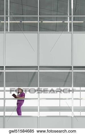 Female doctor talking on a mobile phone in a hospital View Large Photo Image Stock Photography - Female doctor talking on a mobile phone in a hospital. Fotosearch