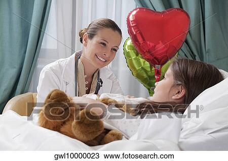 Female doctor talking with a girl in a hospital ward View Large Photo Image Stock Image - Female doctor talking with a girl in a hospital ward. Fotosearch