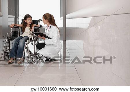 Stock Image - Female doctor with a patient in a wheelchair. Fotosearch
