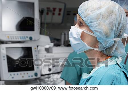 Female doctor working on a cardiac monitor View Large Photo Image Stock Photo - Female doctor working on a cardiac monitor. Fotosearch