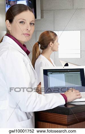 Female doctor working on a laptop View Large Photo Image Stock Image - Female doctor working on a laptop. Fotosearch