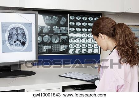 Stock Image - Female doctor writing a report. Fotosearch