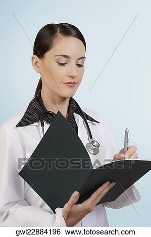 Female doctor writing in a file View Large Photo Image Stock Photograph - Female doctor writing in a file. Fotosearch