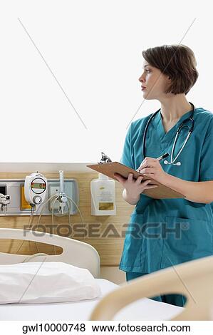 Female doctor writing on a clipboard View Large Photo Image Stock Photo - Female doctor writing on a clipboard. Fotosearch