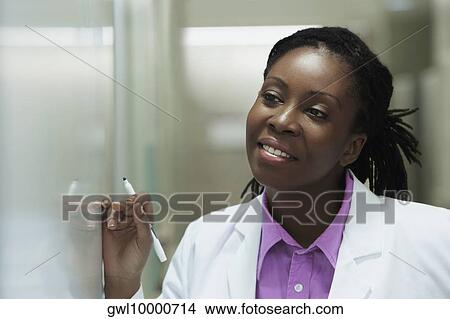 Female doctor writing on a whiteboard in a hospital View Large Photo Image Picture - Female doctor writing on a whiteboard in a hospital. Fotosearch