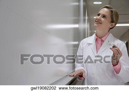 Female doctor writing on a whiteboard in a hospital View Large Photo Image Stock Image - Female doctor writing on a whiteboard in a hospital. Fotosearch