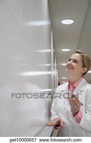 Female doctor writing on a whiteboard in a hospital View Large Photo Image Stock Photo - Female doctor writing on a whiteboard in a hospital. Fotosearch