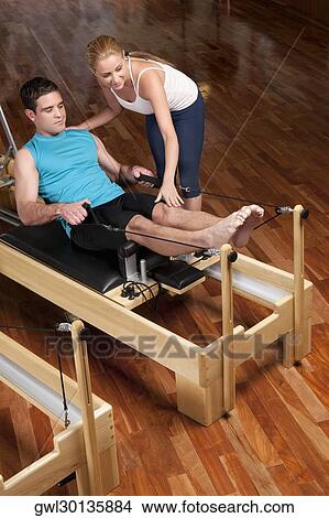 Female instructor assisting a man in a gym View Large Photo Image Picture - Female instructor assisting a man in a gym. Fotosearch