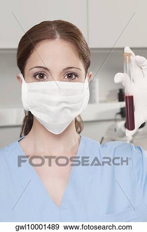 Female lab technician analyzing a blood sample in a test tube View Large Photo Image Stock Photo - Female lab technician analyzing a blood sample in a test tube. Fotosearch
