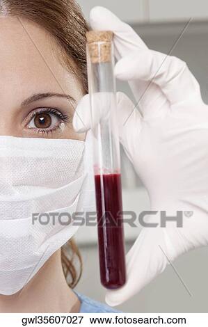 Female lab technician analyzing a blood sample in a test tube View Large Photo Image Stock Photo - Female lab technician analyzing a blood sample in a test tube. Fotosearch