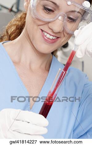 Female lab technician analyzing a blood sample in a test tube View Large Photo Image Stock Photo - Female lab technician analyzing a blood sample in a test tube. Fotosearch