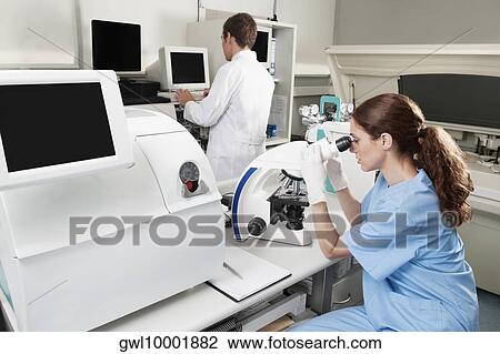 Female lab technician analyzing a sample through a microscope View Large Photo Image Stock Image - Female lab technician analyzing a sample through a microscope. Fotosearch