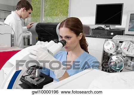 Female lab technician analyzing a sample through a microscope View Large Photo Image Stock Photograph - Female lab technician analyzing a sample through a microscope. Fotosearch