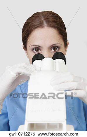 Female lab technician analyzing a sample through a microscope View Large Photo Image Stock Photography - Female lab technician analyzing a sample through a microscope. Fotosearch