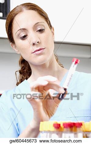 Female lab technician holding blood sample in a test tube View Large Photo Image Stock Image - Female lab technician holding blood sample in a test tube. Fotosearch