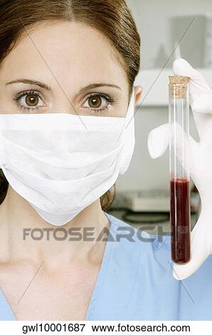 Female lab technician holding blood sample in a test tube View Large Photo Image Stock Photo - Female lab technician holding blood sample in a test tube. Fotosearch
