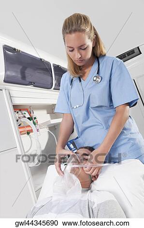 Female nurse assisting a patient in an ambulance View Large Photo Image Stock Image - Female nurse assisting a patient in an ambulance. Fotosearch