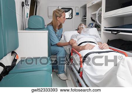 Female nurse assisting a patient in an ambulance View Large Photo Image Stock Image - Female nurse assisting a patient in an ambulance. Fotosearch