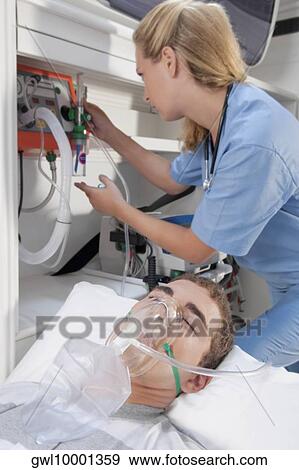 Female nurse assisting a patient in an ambulance View Large Photo Image Stock Photo - Female nurse assisting a patient in an ambulance. Fotosearch