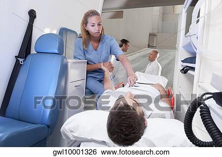 Female nurse assisting a patient in an ambulance View Large Photo Image Stock Photograph - Female nurse assisting a patient in an ambulance. Fotosearch