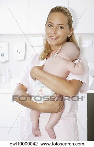 Female nurse carrying a newborn baby View Large Photo Image Stock Image - Female nurse carrying a newborn baby. Fotosearch