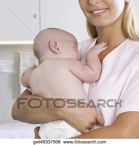 Female nurse carrying a newborn baby View Large Photo Image Stock Photograph - Female nurse carrying a newborn baby. Fotosearch