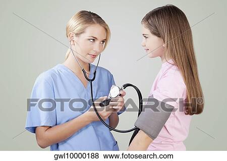 Female nurse checking the blood pressure of a girl View Large Photo Image Stock Photo - Female nurse checking the blood pressure of a girl. Fotosearch