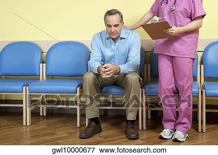 Female nurse consoling a patient in the waiting room View Large Photo Image Stock Photo - Female nurse consoling a patient in the waiting room. Fotosearch
