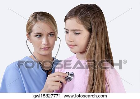 Female nurse examining a girl with a stethoscope View Large Photo Image Stock Image - Female nurse examining a girl with a stethoscope. Fotosearch