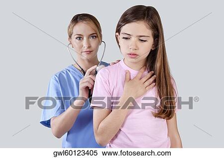 Stock Photography - Female nurse examining a girl with a stethoscope. Fotosearch