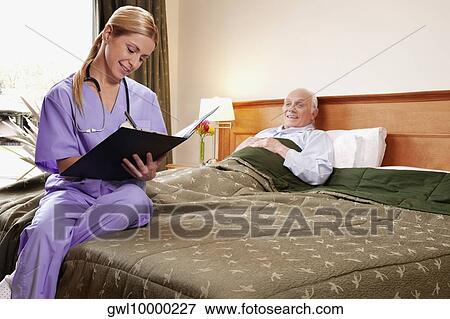 Stock Photo - Female nurse preparing the medical report of a patient. Fotosearch