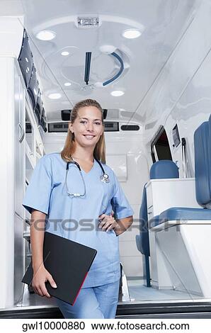 Female nurse standing in front of an ambulance View Large Photo Image Stock Image - Female nurse standing in front of an ambulance. Fotosearch