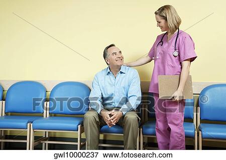 Female nurse talking to a patient in the waiting room View Large Photo Image Stock Photo - Female nurse talking to a patient in the waiting room. Fotosearch