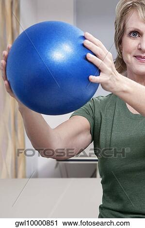 Stock Image - Female patient exercising with a fitness ball. Fotosearch