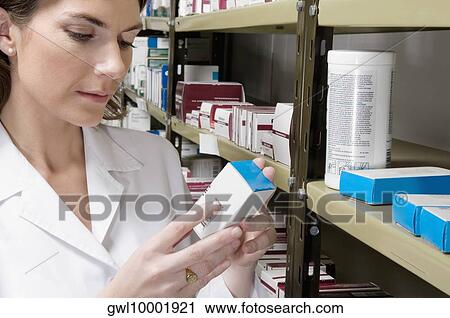 Stock Image - Female pharmacist checking the medicines in a medical store. Fotosearch