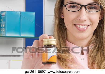 Female pharmacist showing a medicine bottle View Large Photo Image Stock Photo - Female pharmacist showing a medicine bottle. Fotosearch