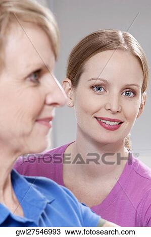 Female physiotherapist smiling with a patient View Large Photo Image Stock Image - Female physiotherapist smiling with a patient. Fotosearch