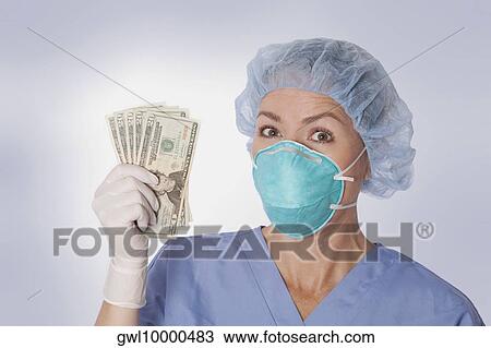 Female surgeon holding currency notes View Large Photo Image Stock Image - Female surgeon holding currency notes. Fotosearch