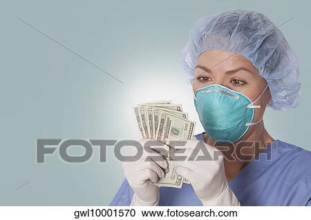 Female surgeon holding currency notes View Large Photo Image Stock Image - Female surgeon holding currency notes. Fotosearch