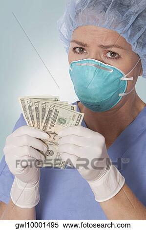 Female surgeon holding currency notes View Large Photo Image Stock Photography - Female surgeon holding currency notes. Fotosearch