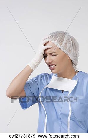 Female surgeon suffering from a headache View Large Photo Image Stock Photo - Female surgeon suffering from a headache. Fotosearch